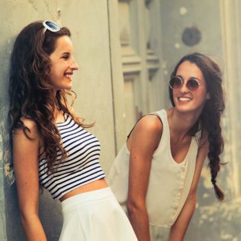 two young women laughing outside building