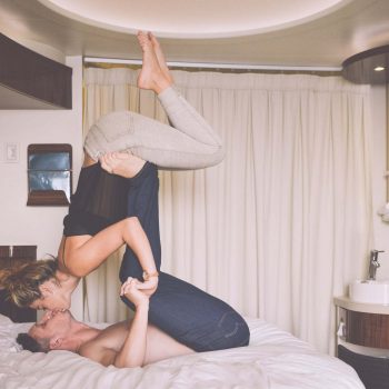 couple in bed kissing and doing AcroYoga