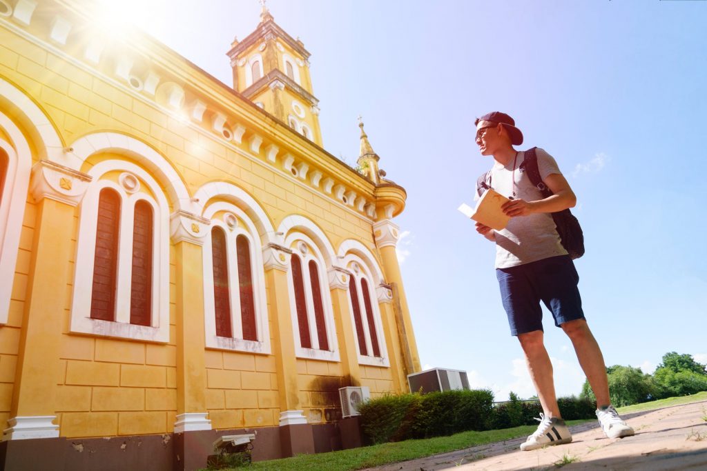 backpacker with book outside historic building