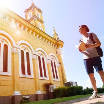 backpacker with book outside historic building