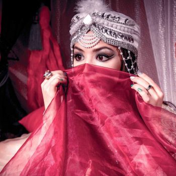 elaborately adorned woman covering face with veil